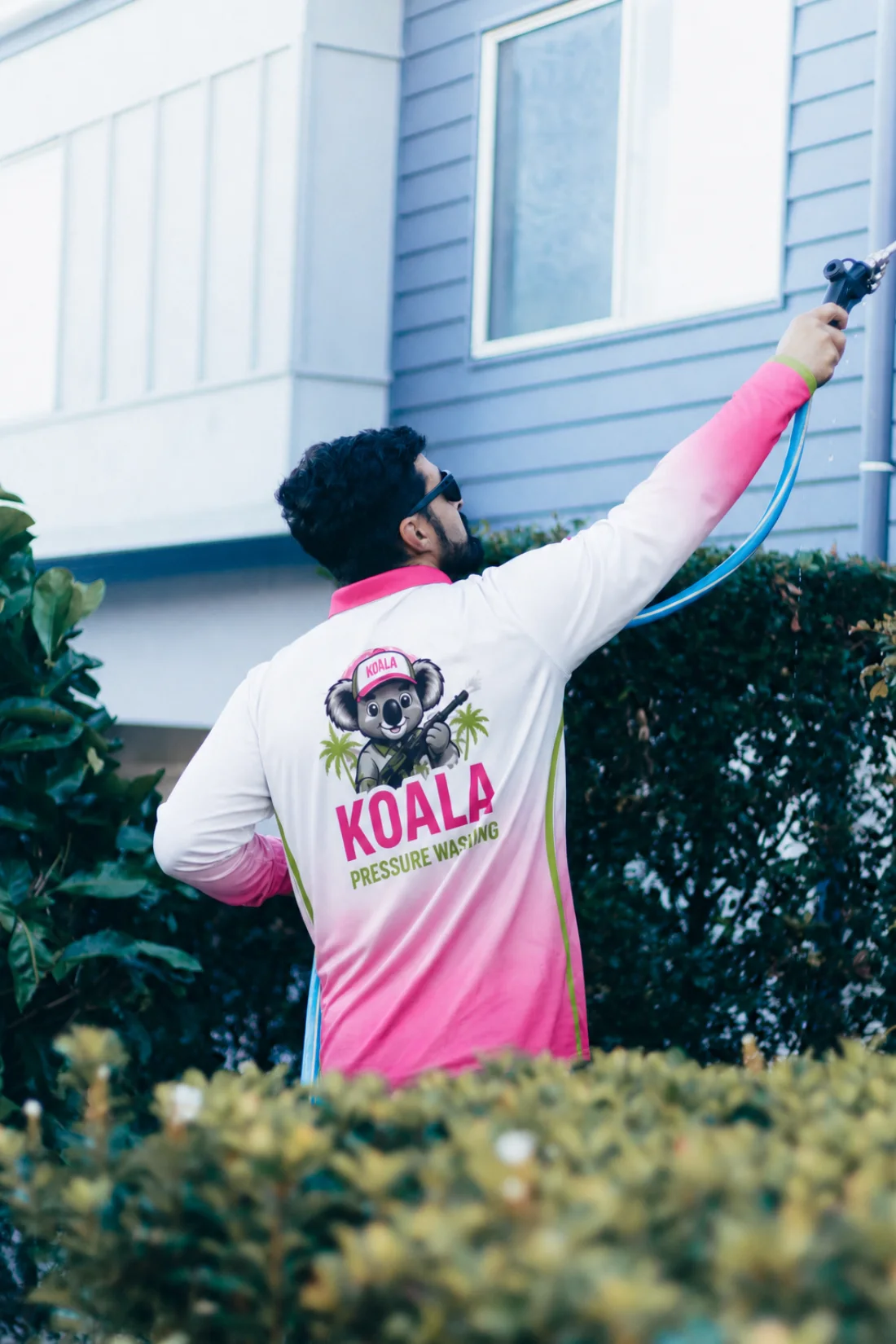 Koala technician washing an upper exterior wall