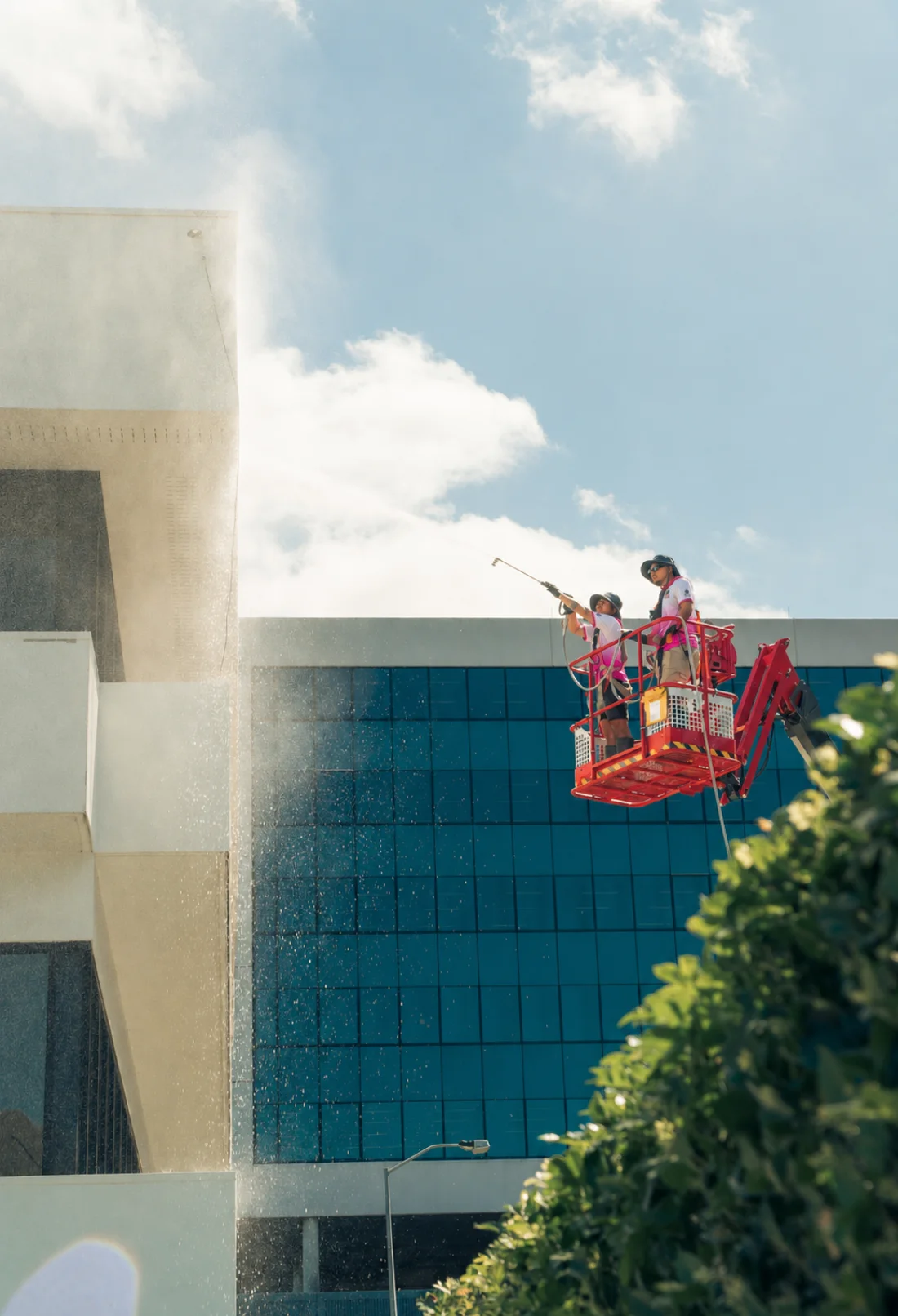Koala Pressure Washing technicians in uniform cleaning a commercial building